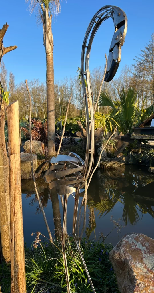 sculpture métal recyclé dans un jardin sculpture métal artistique dans un massif végétal sculpture décorative métal recyclé extérieur sculpture AMupcycling dans un jardin paysager